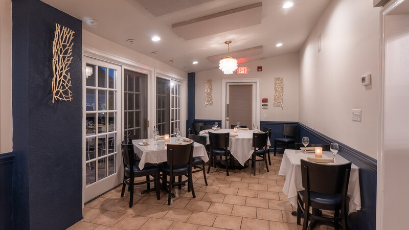 Corner of side dining room with three square tables